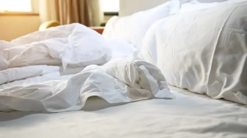 Person, die ein Bett macht